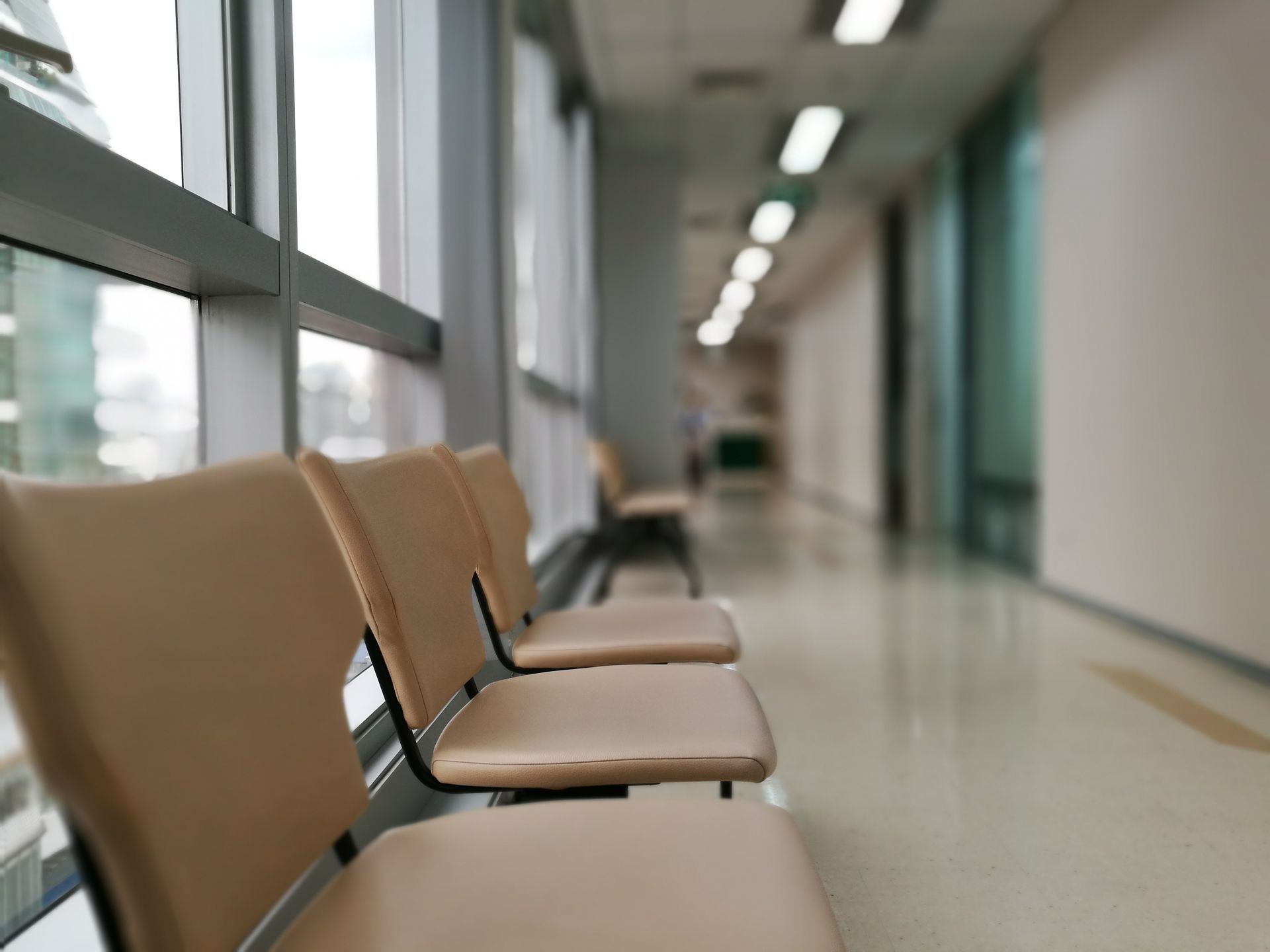 Corredor de hospital com uma fileira de cadeiras de espera vazias