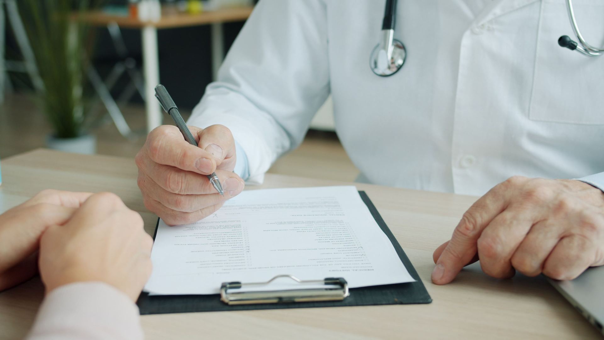 Médico preenchendo um formulário em prancheta